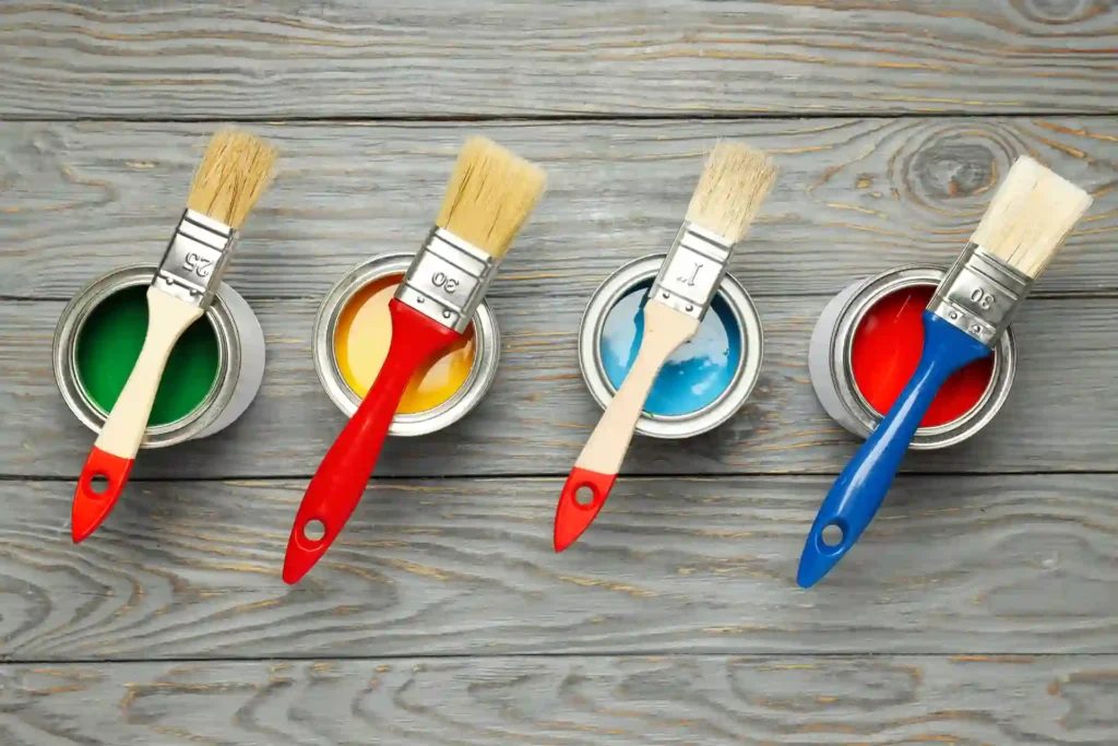 Paint brushes resting on open paint cans for a guide on What Is the Best Deck Paint